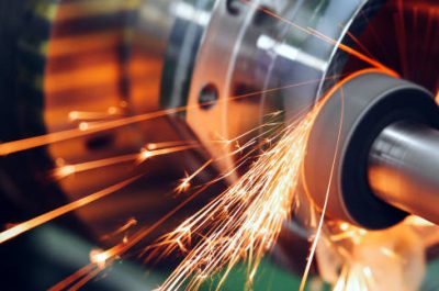 sparks flying while machine griding and finishing metal in factory